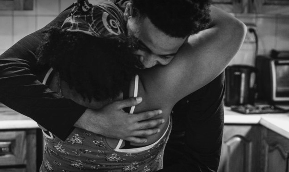 Son and mother hugging in kitchen